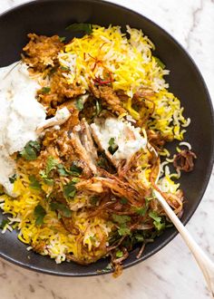 a black bowl filled with rice and meat