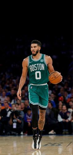 boston basketball player dribbling the ball down the court in front of an audience