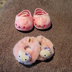 two hello kitty slippers are laying on the floor next to a pair of pink shoes