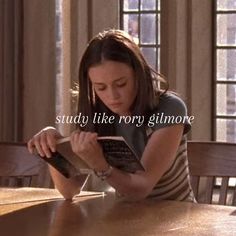 a woman sitting at a table reading a book with the words study like roxy glimore