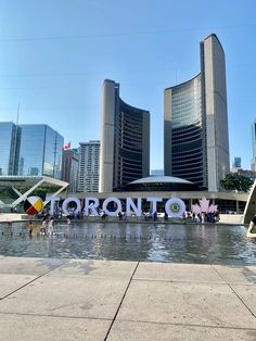 people are walking around in front of a large sign that says toronto on the water