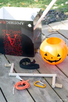 an orange pumpkin sitting on top of a wooden table next to scissors and other items