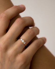 a woman's hand with a diamond ring on top of her left arm,