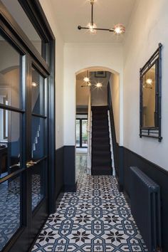 the hallway is decorated in black and white with an intricate tile pattern on the floor