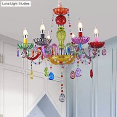 a colorful chandelier hanging from the ceiling in a room with white cupboards