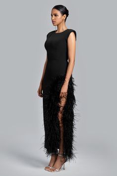 a woman in a black dress with feathers on it