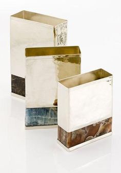 three different types of vases sitting on top of a white surface with gold foil