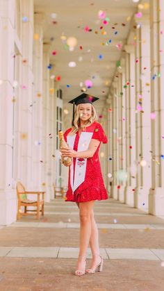 a woman in a graduation cap and gown is holding her diploma while confetti falls around her