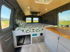 the interior of a camper with an extra bed and storage compartment in the back