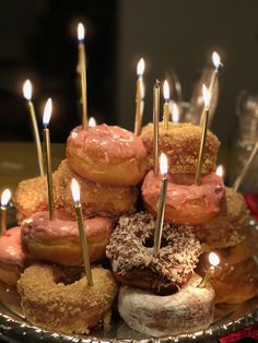 many donuts are stacked on top of each other with candles sticking out of them