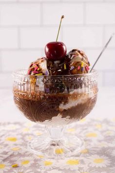 an ice cream sundae with cherries and sprinkles in a glass bowl