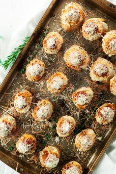 small appetizers with cheese and parmesan sprinkles on a baking sheet