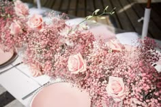 pink flowers and baby's breath are arranged in vases on a table with plates