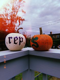 two pumpkins sitting on top of a wooden fence next to each other with the word creep painted on them