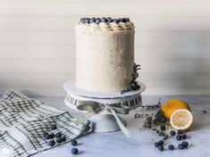 a white cake with blueberries and lemons on a table