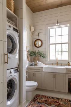 a washer and dryer in a white bathroom with wood paneling on the walls