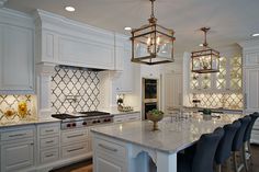 a large kitchen with white cabinets and an island in the middle, surrounded by black chairs