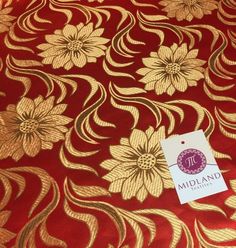 a red and gold fabric with large flowers on the front, along with a white tag that says midland