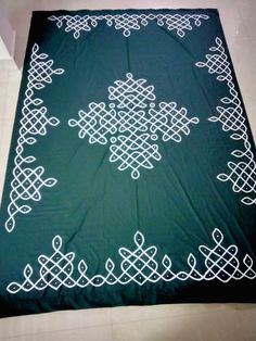 a green blanket with white designs on it