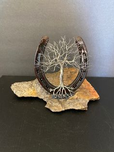 a tree is growing out of an old pair of horseshoes on a piece of rock