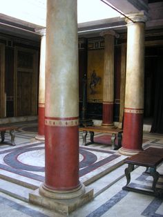 the interior of a building with columns and benches