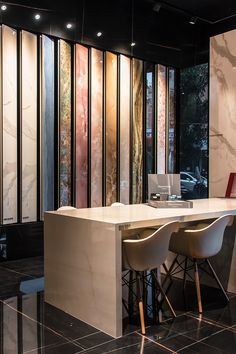 an office with marble walls and white desks in front of large windows that look out onto the street