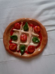 a small pizza with tomatoes and cheese in it on a tablecloth covered table cloth