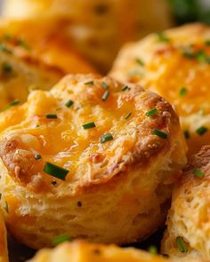 there are some cheesy breads with green onions on top, and one has been cut in half