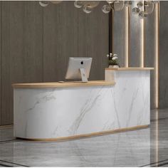 a white marble reception desk with a laptop on it