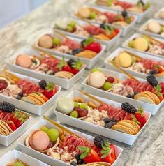 several trays filled with different types of food on top of a marble countertop