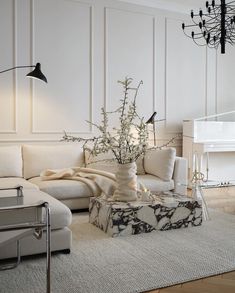 a living room filled with furniture and a white piano