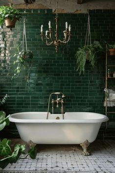 a bathroom with green tiles and a claw foot bathtub in the center, surrounded by greenery