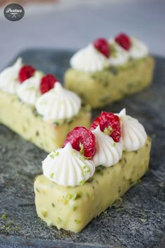 two pieces of cake with whipped cream and raspberries on top sitting on a stone