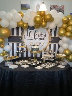 a table topped with balloons and desserts under a sign that says class on it