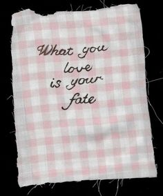 a piece of cloth with the words what you love is your fate