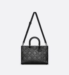 New for the season and appearing in the Spring-Summer 2024 Fashion Show, the Lady D-Sire bag draws inspiration from the iconic elegance of the Lady Dior design. Reimagined with a casual style for an urban look, the black crinkled calfskin is accented by Macrocannage topstitching, while tonal ultra-matte metal D.I.O.R. charms lend a modern touch. Featuring a thin, removable leather shoulder strap, the unique large bag can be carried by hand or worn over the shoulder.. Dior Star, Icon Shoes, Drawing Bag, Dior Book Tote, Wallet Pouch, Backpack Tote Bag, 2024 Fashion, The Lady, Large Bag