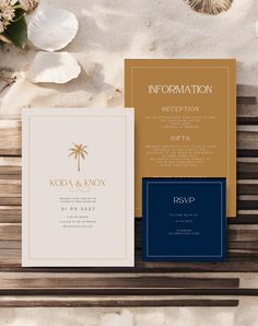 the wedding stationery is laid out on a wooden bench with shells and seashells