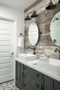 a bathroom with two sinks, mirrors and lights on the wall above them is decorated in wood planks