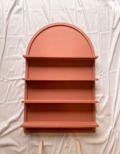 an orange shelf sitting on top of a white sheet