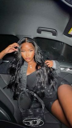 a woman sitting in the back seat of a car with long black hair and stockings on