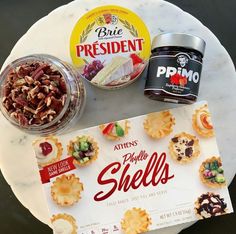 an assortment of snacks including crackers, fruit and yogurt on a marble plate