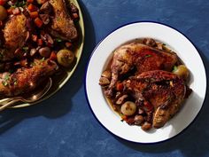 two plates with meat and vegetables on them next to a bowl full of potatoes, carrots and beans