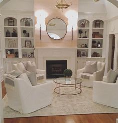 a living room filled with furniture and a fire place in the middle of a room