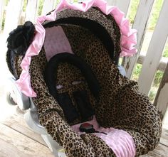 a leopard print baby car seat cover with pink ruffles on the top and bottom