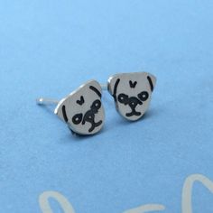 These adorable stud earrings are based on our Pug Lola when she was a puppy. All pugs are mischievous and Lola is no exception.  These earrings are handmade from sterling silver. The design has been etched onto the surface and then oxidised to turn the detail black. The earrings have then been polished for a lovely shiny surface. They are approx 8mm wide.   All items come gift wrapped in a blue box with matching pug ribbon so make a wonderful gift for a pug or dog lover.  There are 5 new designs Pug Jewelry, A Pug, Blue Box, Jewelry Sterling Silver, A Puppy, Playful Design, Designer Earrings, Custom Items, Pug