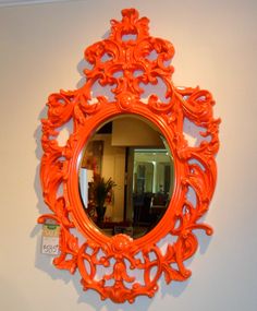 an orange mirror is hanging on the wall