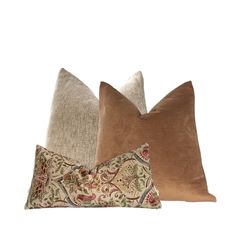 three pillows with different patterns on them, one in brown and the other in tan