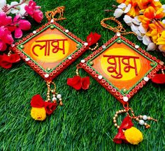 two colorfully decorated earrings sitting on top of a green grass covered field next to flowers