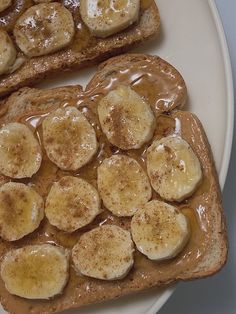 two pieces of bread with peanut butter and bananas on them