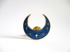 "Inspired by ancient lunula talismans, these Celestial Glitter Moon hard enamel pins combine modern design with old-world magic.  Comes in dazzling dark blue glitter enamel and a gold-plated finish.  Part of the Celestial Visions collection. * 1\" cloisonné-style hard enamel pin with blue glitter enamel and gold metal plating. * Comes with a gold-plated butterfly clutch. * Laser-engraved on the back to certify authenticity. * Individually packaged on a backing card with a gold metallic finish. * Fantasy Necklace, Ita Bag, Backpack Pins, Purple Fire, Magical Jewelry, Cool Pins, Bag Ideas, Hard Enamel Pin, Blue Glitter